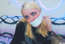 Blonde girl tape gagged tight with microfoam tape at selfgags.com