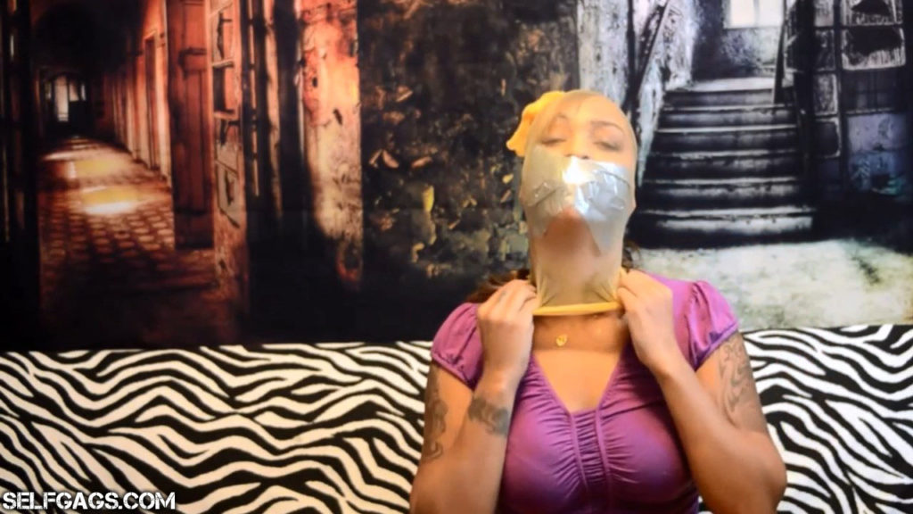 Tape gagged latina with pantyhose head encasement