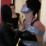 Black haired woman tied up and tape gagged with duct tape by female in leather catsuit