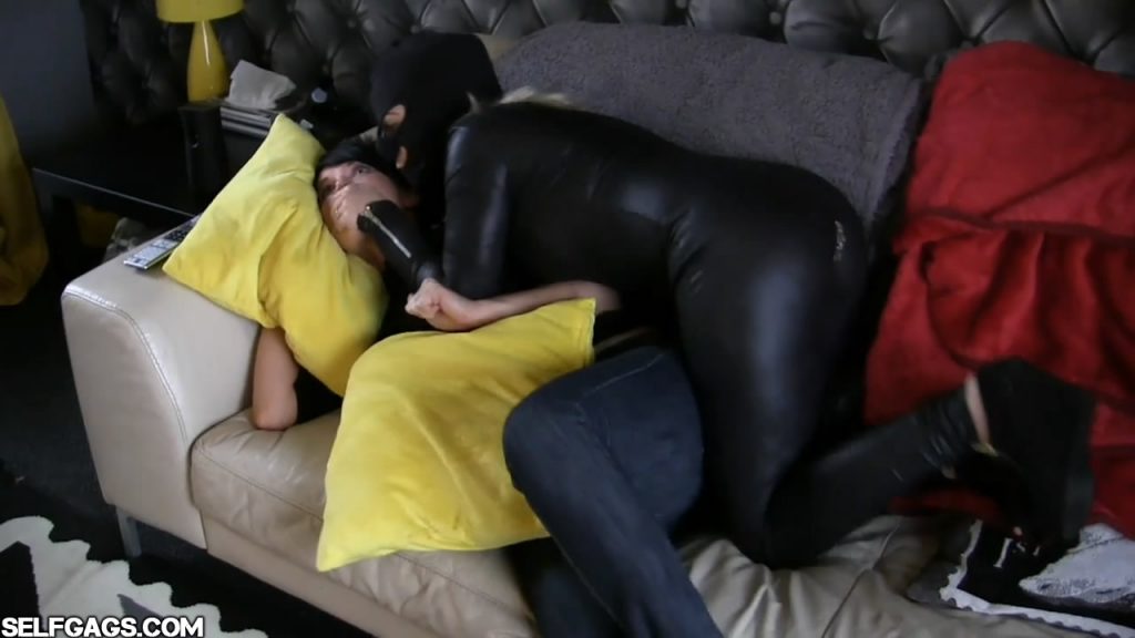 Hand gagged by female in leather catsuit