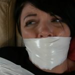 Girl with black hair gagged with white duct tape