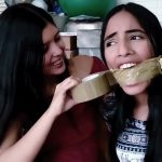 Sexy girl with dark hair gets tape wrap gagged by best friend in bondage