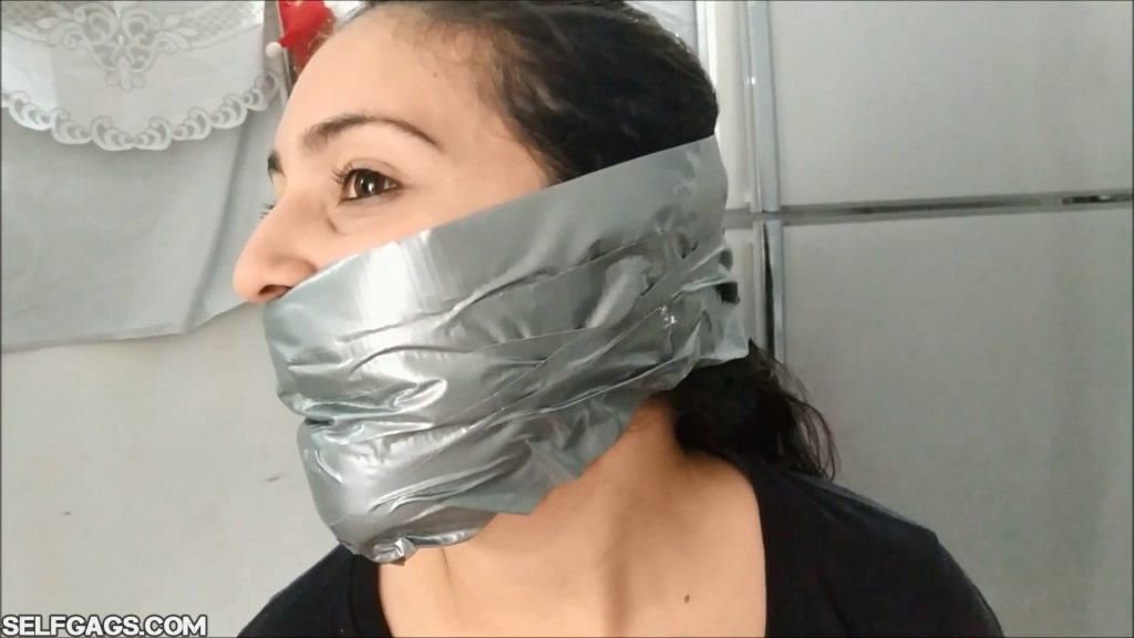 Sexy latina girl with a big duct tape wrap gag around the head