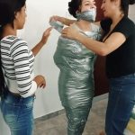 Tape wrap gagged fetish girl trapped in tight silver duct tape mummification bondage