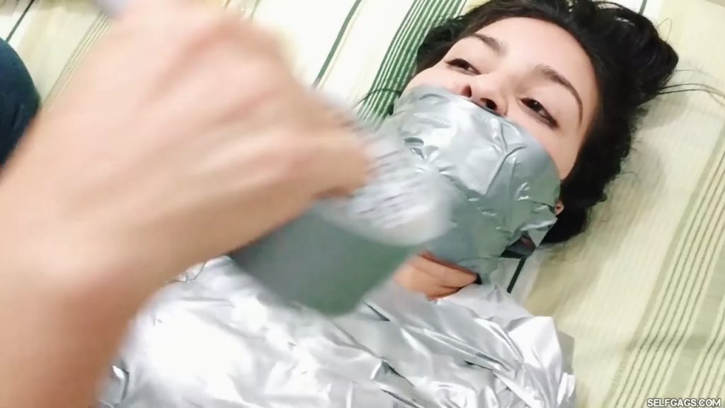 Gagged latina girl tape tied into a duct tape mummy