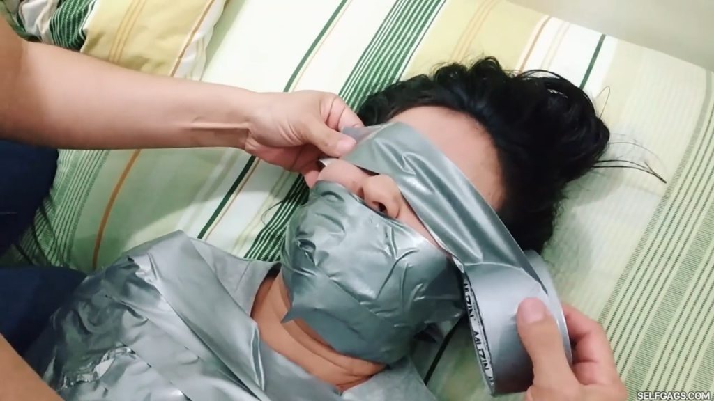 Gagged latina girl tape tied into a duct tape mummy and blindfolded with duct tape