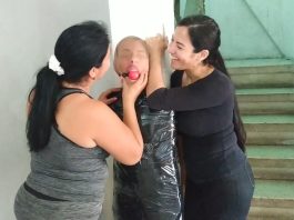 Mummified girl pantyhose hooded and ball gagged by two latina milfs