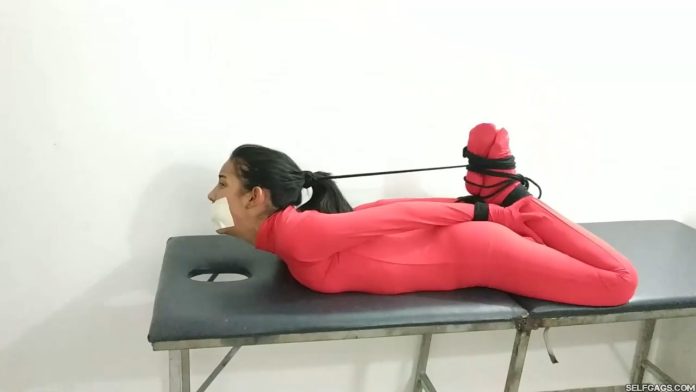Girl in red bodysuit hogtied and gagged