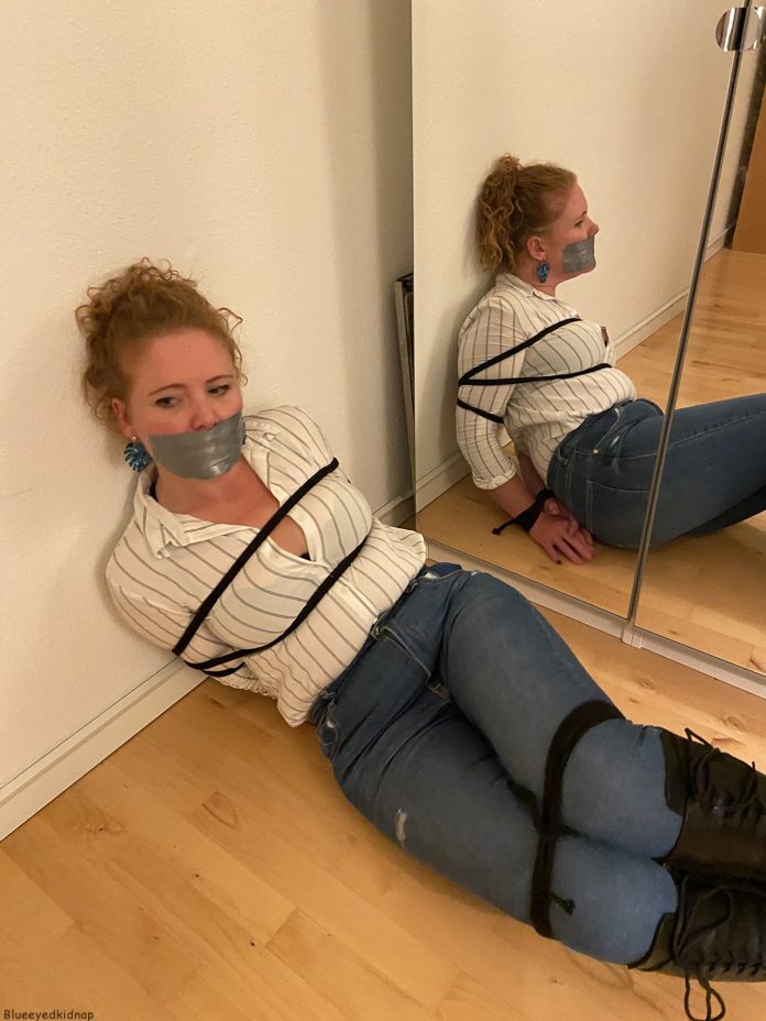 Gagged woman tied up in jeans and boots