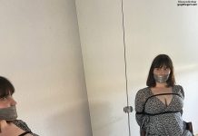 Tape gagged woman wearing dress in bondage