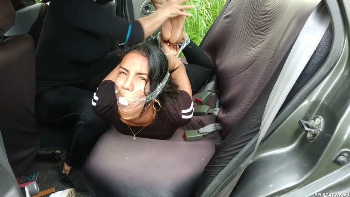Barefoot girl hogtied in car