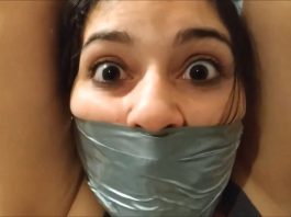 Wide eyed girl with duct tape wrapped around her face