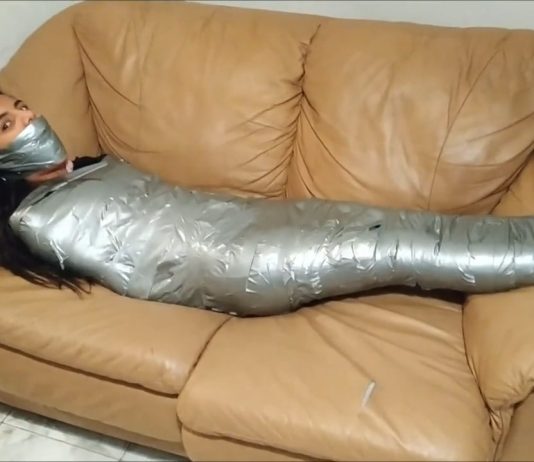 Sock Gagged Girl Wrapped Up Tight On Sofa Girl restrained with duct tape wrapped around her body from her feet to her shoulders