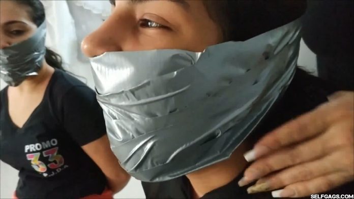 Two bondage girls are heavily gagged with sticky duct tape
