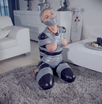 Topless Blonde Frogtied And Heavily Gagged A gagged woman in a catsuit has her perky tits exposed in bondage. She loves being tied up and gagged.