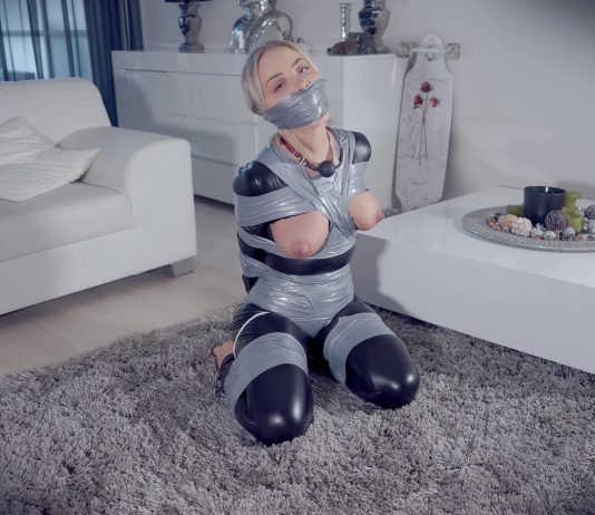 Topless Blonde Frogtied And Heavily Gagged A gagged woman in a catsuit has her perky tits exposed in bondage. She loves being tied up and gagged.