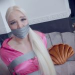 Blonde woman tape wrap gagged in tight tape bondage