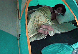 Struggling woman bound and gagged in a tent in the woods