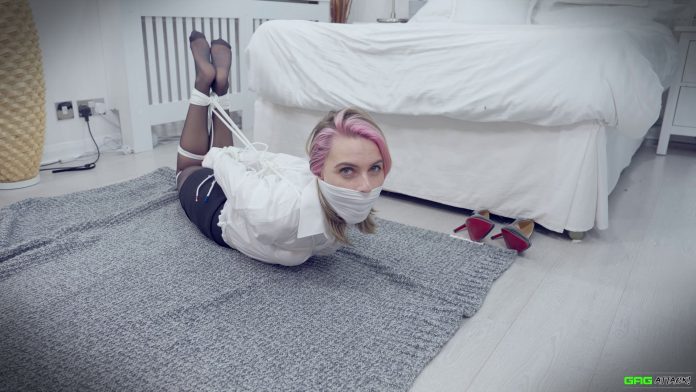 Woman wearing pantyhose is hogtied and otm gagged in blouse on the floor