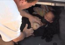 A bound and gagged woman in a car trunk has her tits groped by a man