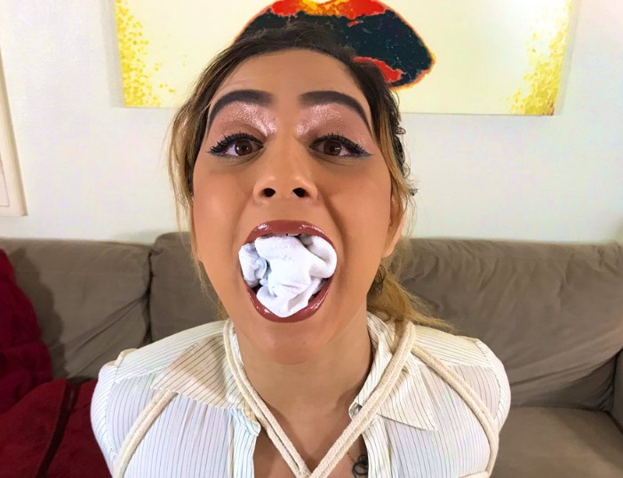 A rope bound woman have her mouth stuffed full