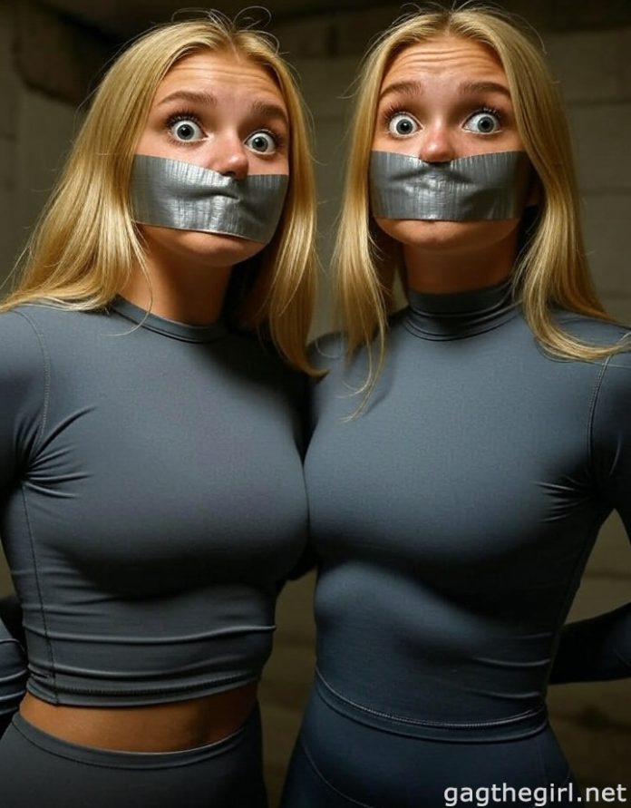 18-year-old American sporty twin sisters, duct tape gagged with arms tied, distressed eyes, in tight grey gym wear in a basement setting.