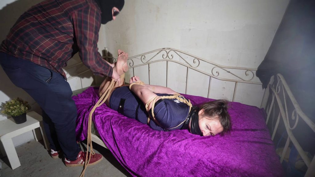 Officer Taylor is tied, tape gagged, and hogtied in uniform—feisty, loud, and totally helpless in this bondage fantasy.