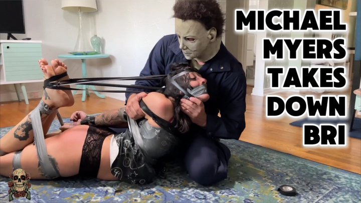 Skull Candy Bri hogtied and tape gagged by Michael Myers in a Halloween bondage scene.
