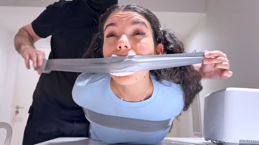 Close-up of Addy gagged with socks, her mouth sealed in tight tape
