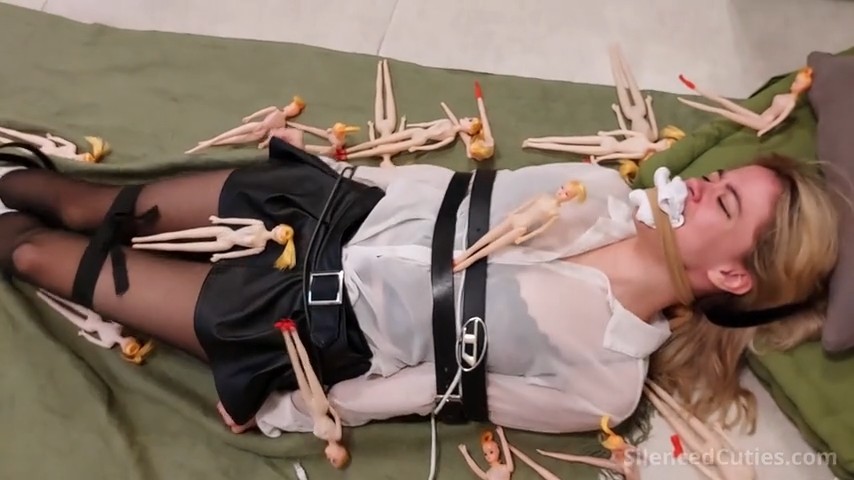 Nani tied on the floor in pantyhose, gagged with sock and pantyhose wrap, surrounded by living dolls