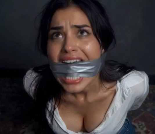 Brunette Duct Tape Cleave Gagged & Struggling Helplessly on Floor – AI Bondage Woman with duct tape over her mouth, looking upward with a distressed expression in a dim room.