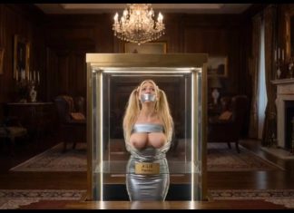 Missing Teacher Julie Millard Duct Taped & Displayed in Billionaire’s Glass Case – AI Bondage Wide shot of the glass display case elevating with bound and gagged teacher Julie Millard inside opulent room