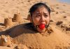 Southeast Asian Harness Ballgagged & Bucket Hooded on Beach – AI Bondage Close up of terrified Southeast Asian beauty with thick harness ball gag strapped in her mouth, eyes wide with fear