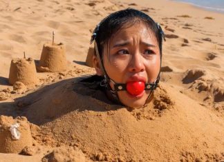Southeast Asian Harness Ballgagged & Bucket Hooded on Beach – AI Bondage Close up of terrified Southeast Asian beauty with thick harness ball gag strapped in her mouth, eyes wide with fear