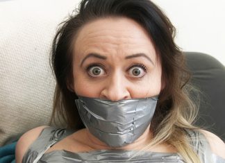 Why Men Find Tape-Gagged Women So Attractive Brunette woman with wide eyes tightly gagged with multiple layers of silver duct tape covering her mouth and lower face