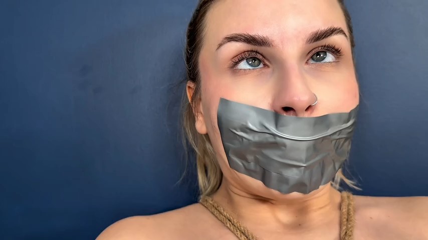 Isla White close-up grey duct tape gag with wide blue eyes – MilaAmoraBondage