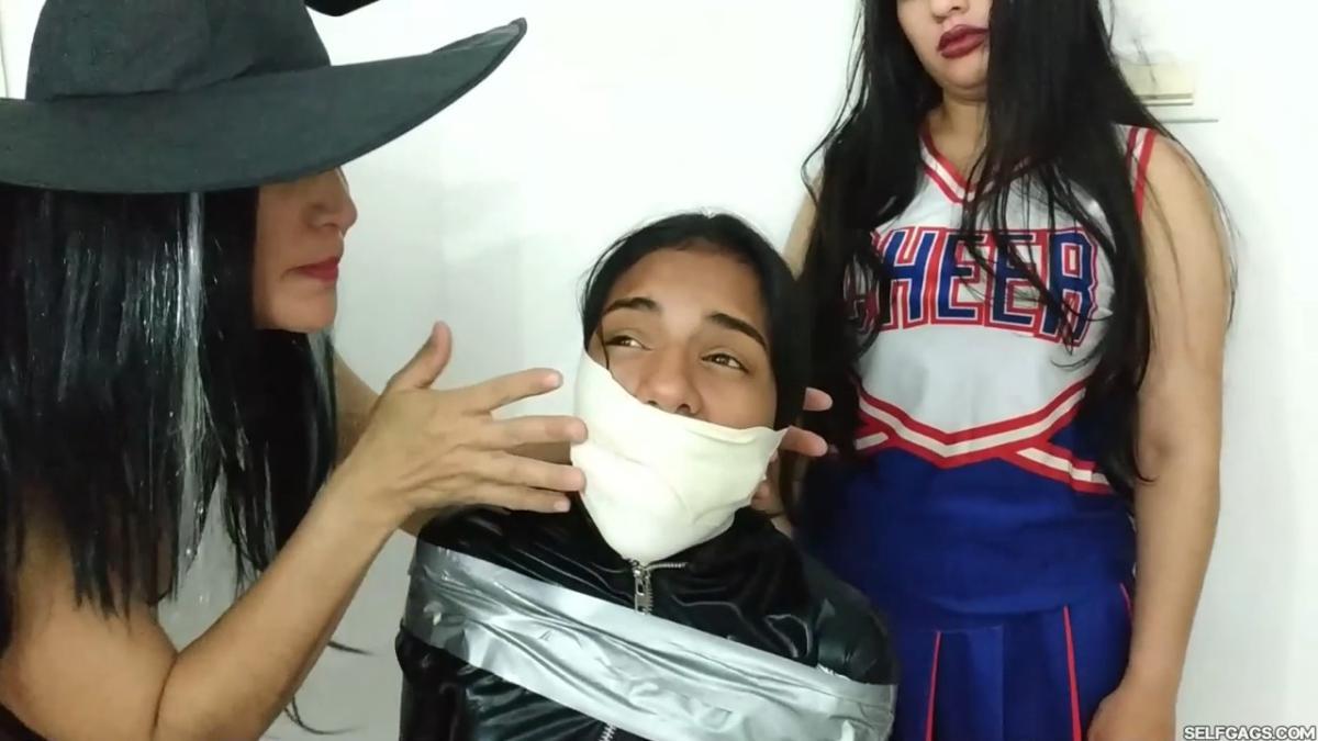 girl in catsuit bound and gagged by witch and cheerleader for halloween