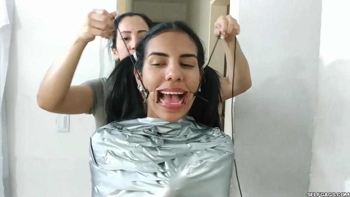 Cute girl gets duct tape mummified BDSM training by female bondage photographer