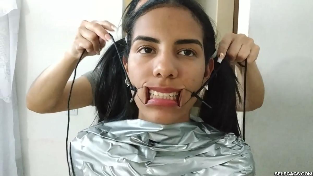 Cute girl gets duct tape mummified BDSM training by female bondage photographer