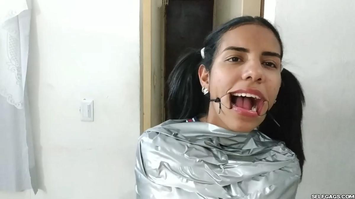 Cute girl gets duct tape mummified BDSM training by female bondage photographer