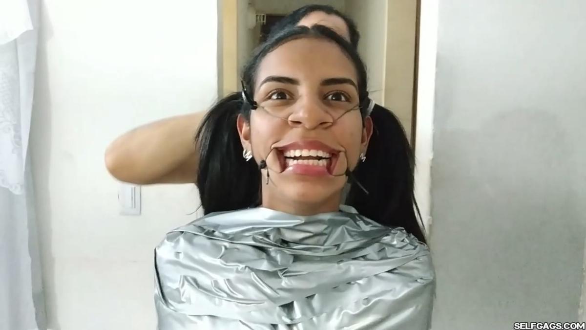 Cute girl gets duct tape mummified BDSM training by female bondage photographer