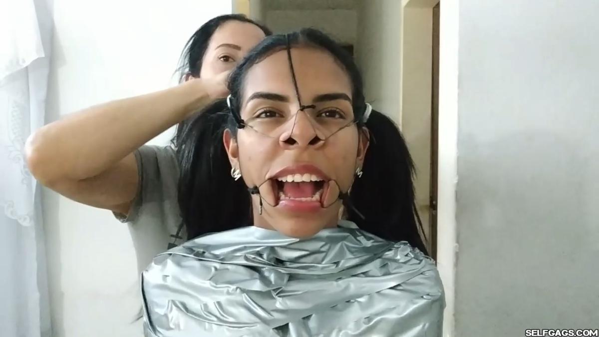 Cute girl gets duct tape mummified BDSM training by female bondage photographer