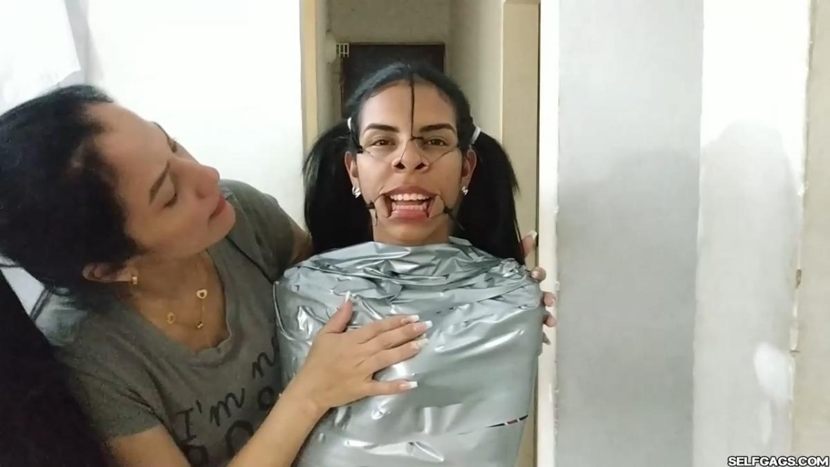 Cute girl gets duct tape mummified BDSM training by female bondage photographer