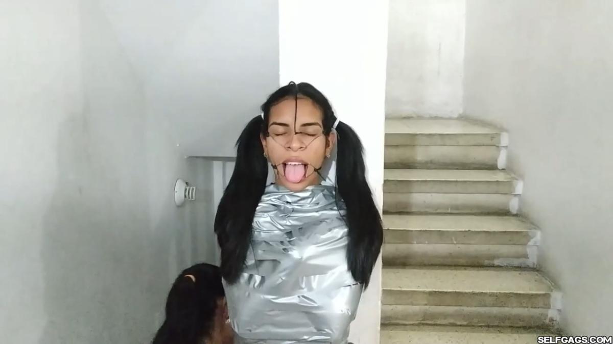 Cute girl gets duct tape mummified BDSM training by female bondage photographer