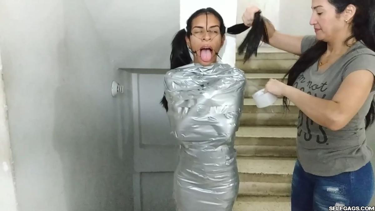 Cute girl gets duct tape mummified BDSM training by female bondage photographer