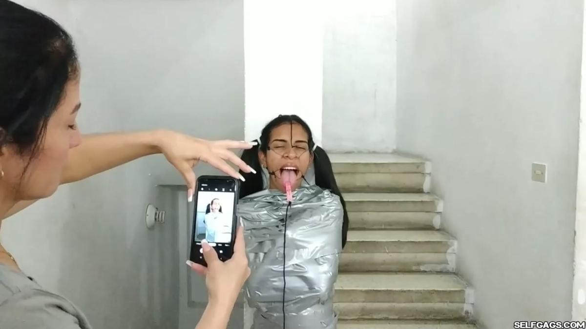 Cute girl gets duct tape mummified BDSM training by female bondage photographer