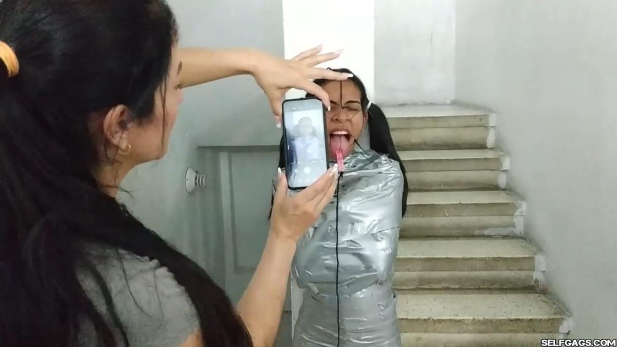 Cute girl gets duct tape mummified BDSM training by female bondage photographer
