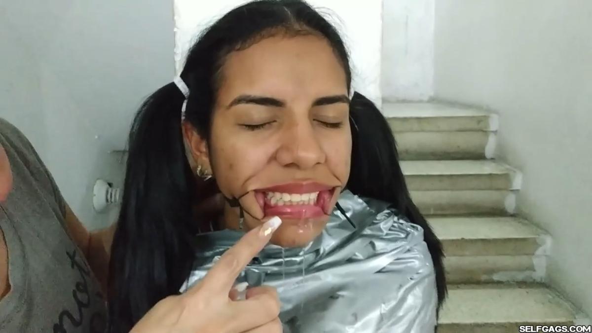 Cute girl gets duct tape mummified BDSM training by female bondage photographer