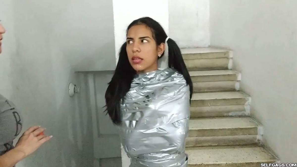 Cute girl gets duct tape mummified BDSM training by female bondage photographer