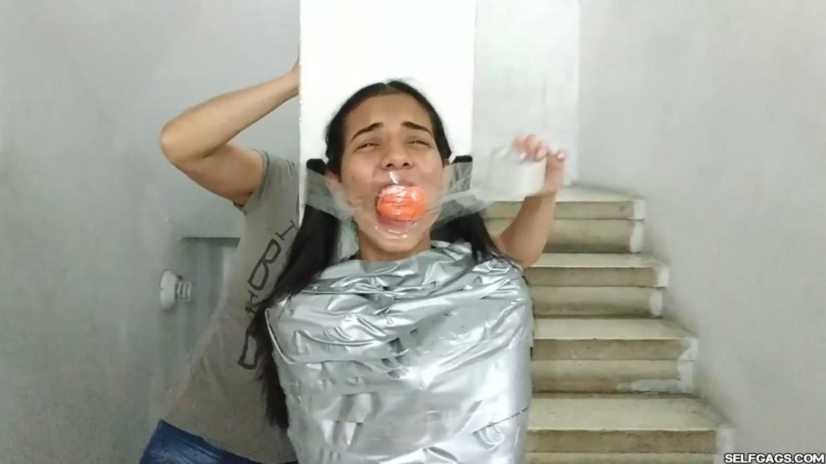 Cute girl gets duct tape mummified BDSM training by female bondage photographer